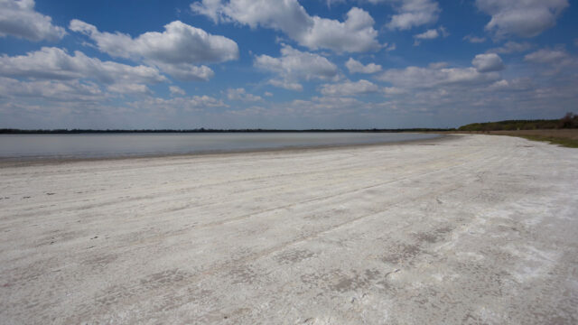 View of receding saline reservoir with a blue sky above