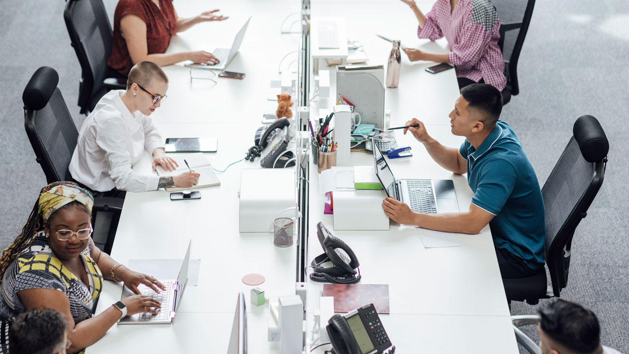 View from above of a bank of desks and people working in front of computers