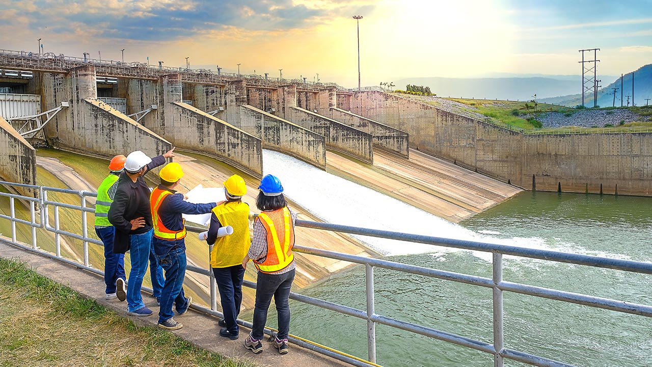 Engineers in PPE review plans at a hydropower facility