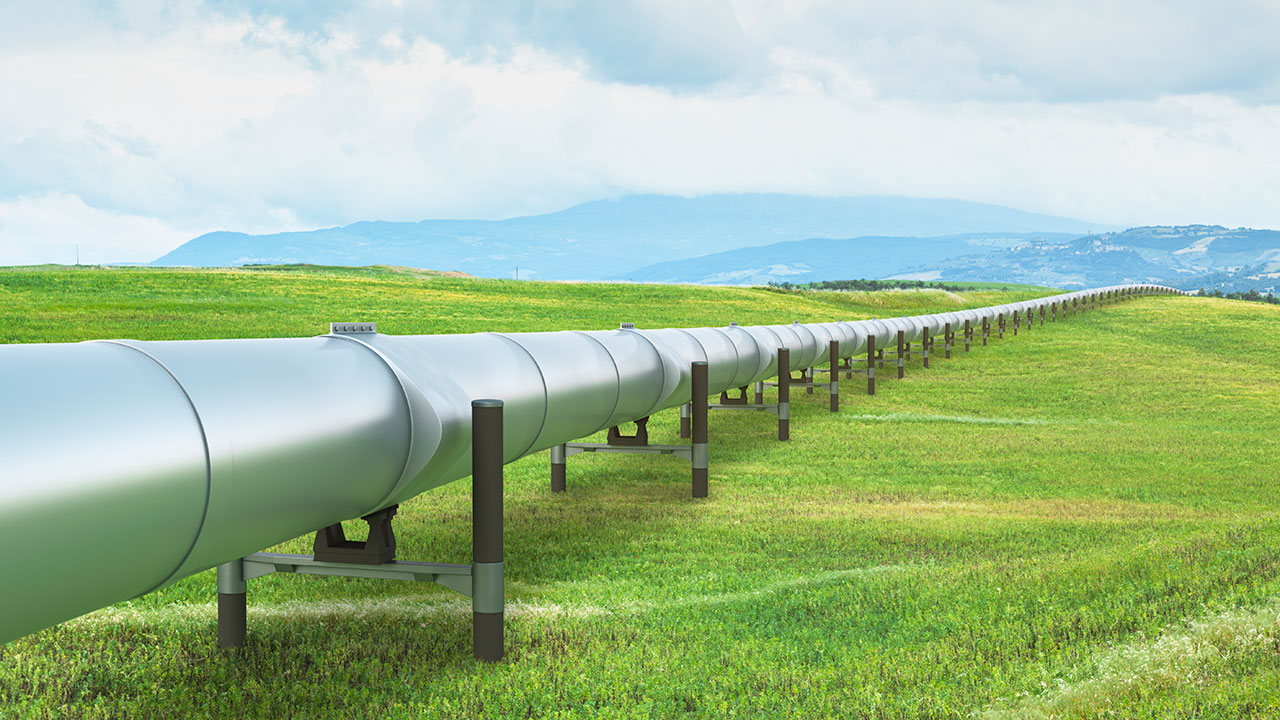 Silver raised pipeline traverses a large grassy expanse