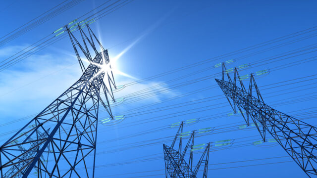 View from below of transmissions lines against the blue sky