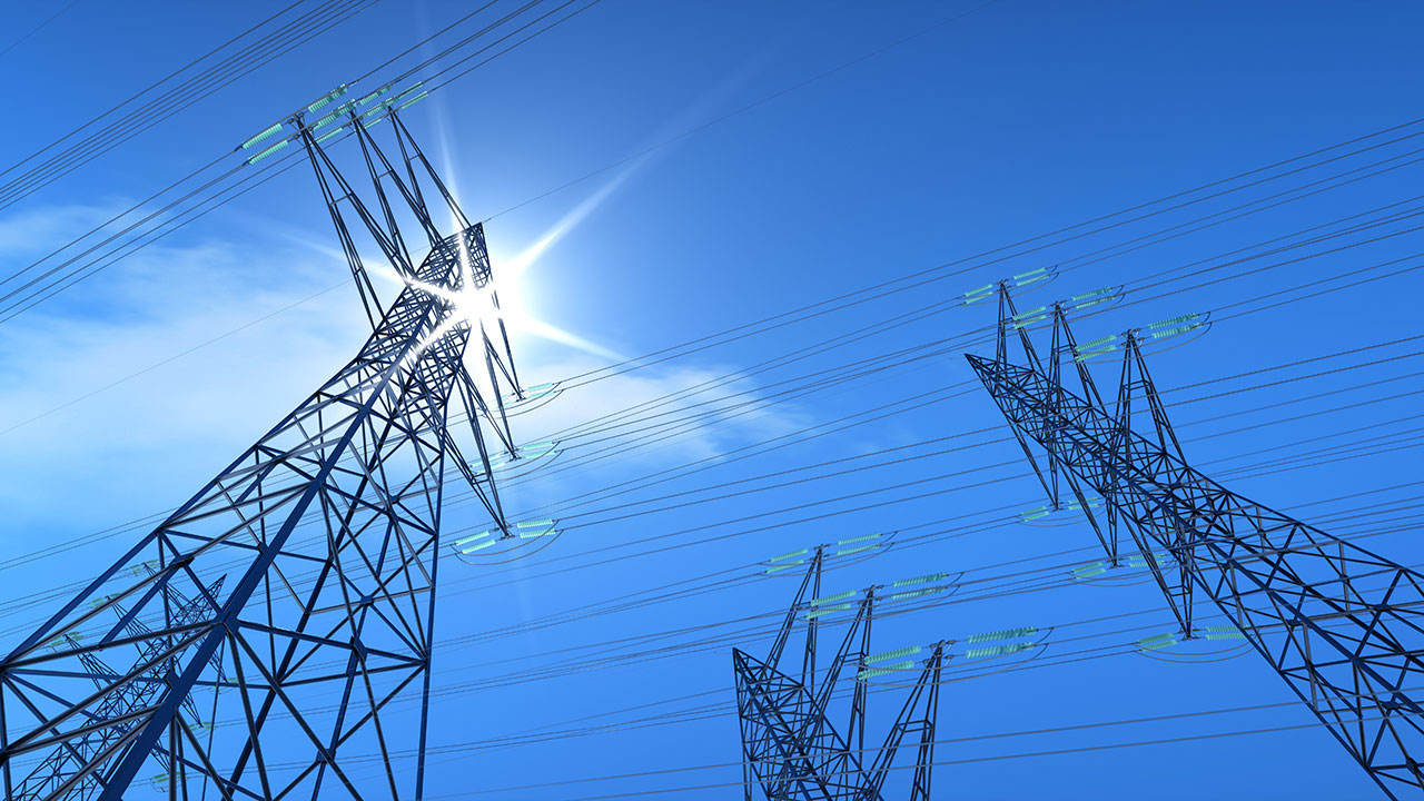 View from below of transmissions lines against the blue sky