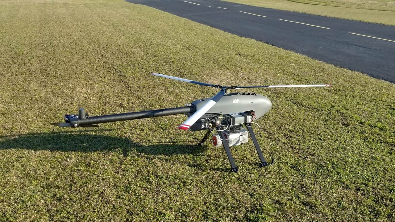 A drone landed on grass next to a landfill road
