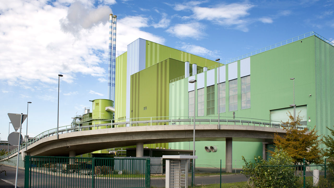 Angled view of a waste incineration facility with a blue sky in the background