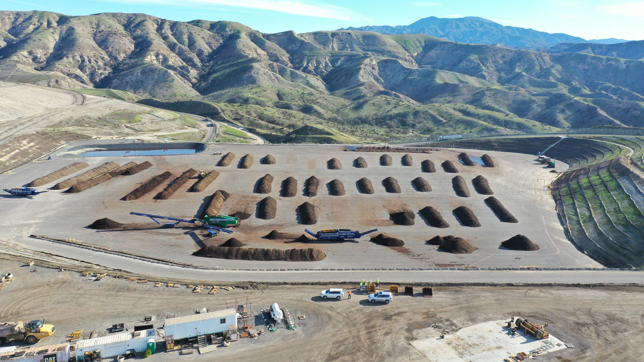 Organic waste composting facility with mountains and a blue sky in the background