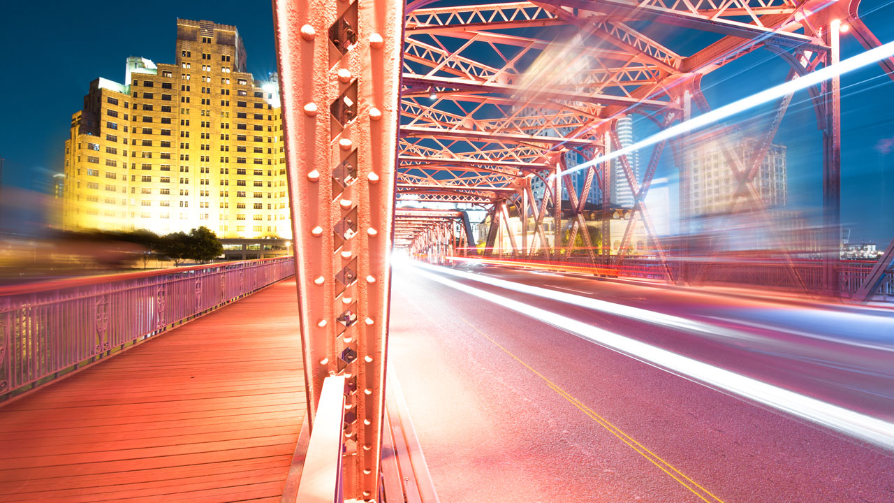 A pink hued nighttime street scene with blurred motion and lights