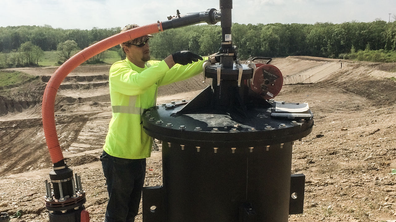 Technician performing maintenance on a landfill gas well