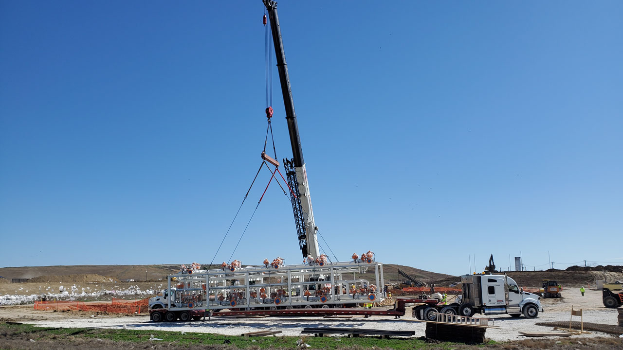 View of a crane during installation of a landfill gas compression and clean-up skid