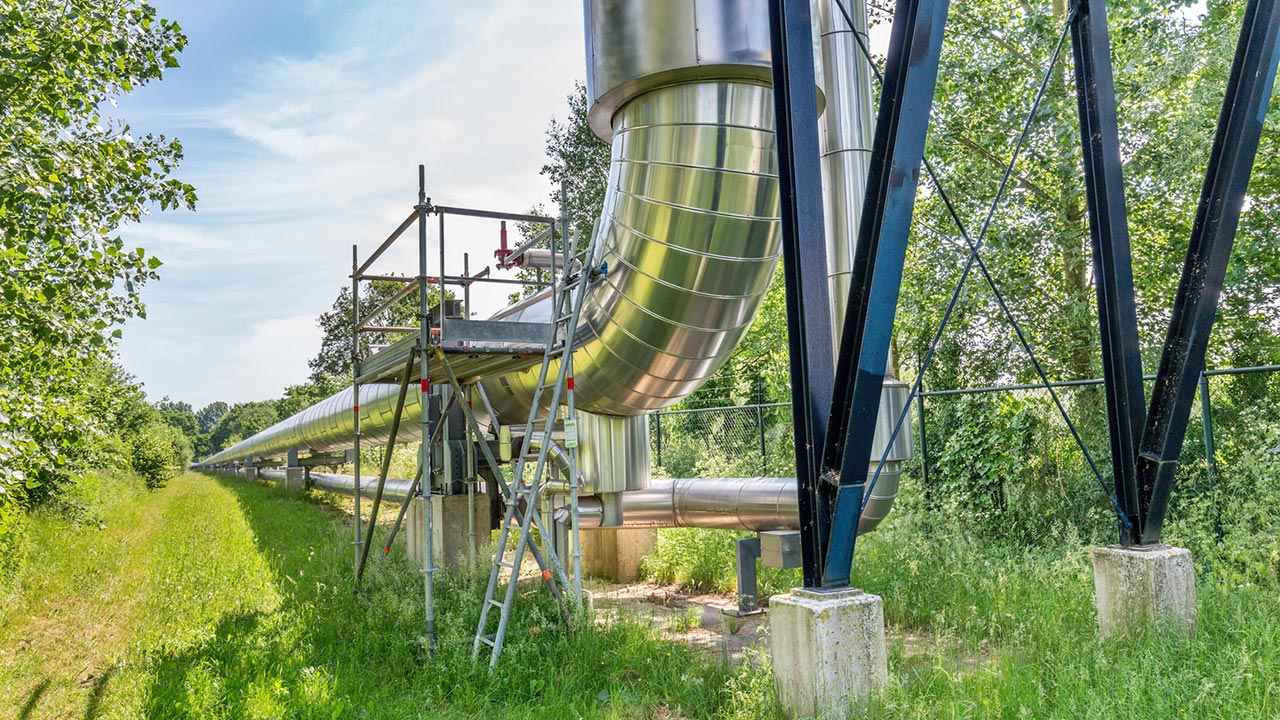 Silver metallic pipeline in grassy field