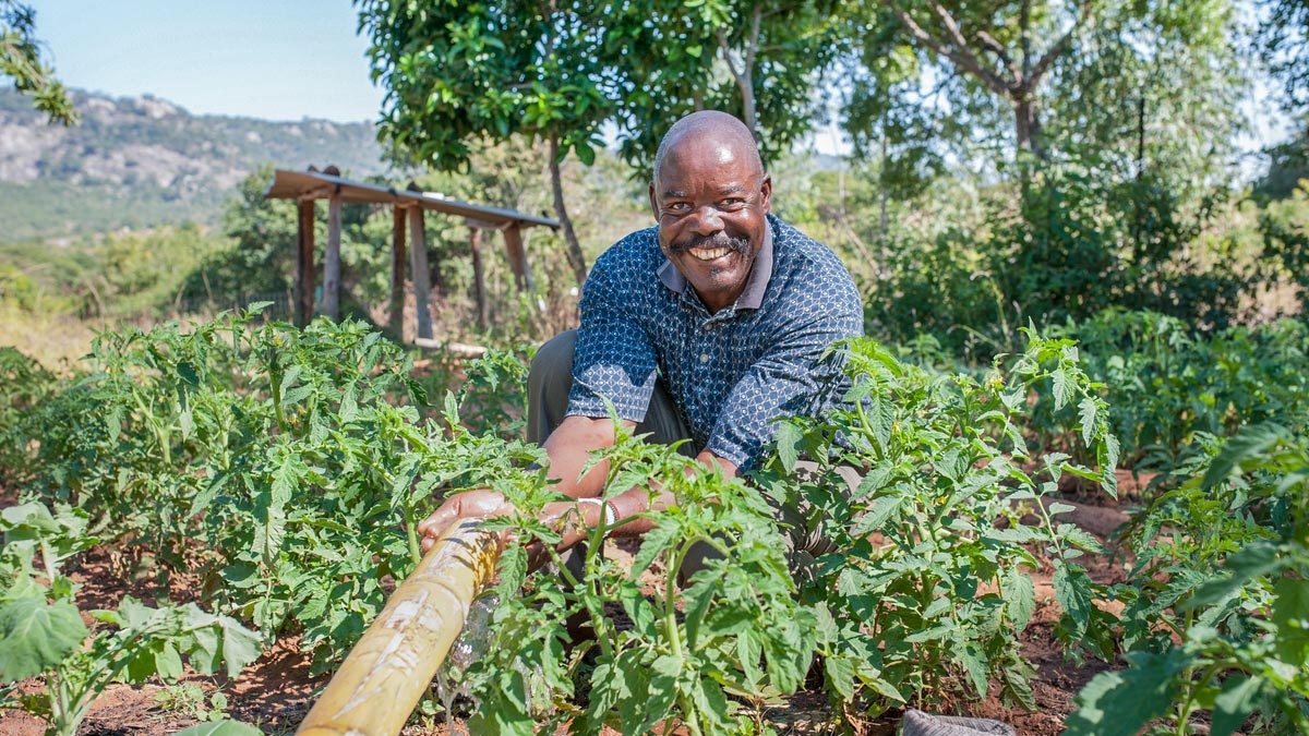 A farmer sits in his field with climate-resilient irrigation technology