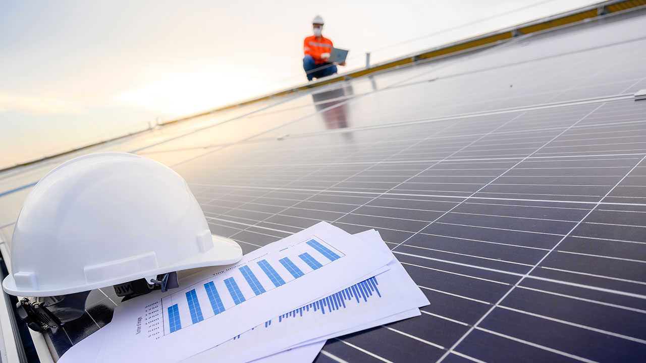 A close up of a hard hat and papers lying on a solar panel