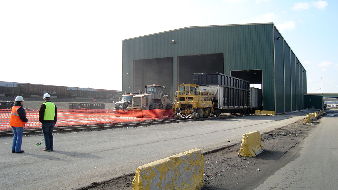 Two Tetra Tech engineers viewing vehicles parked outside facility