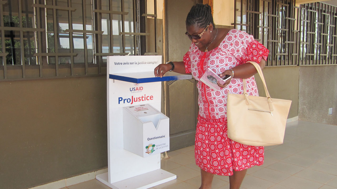 A person in Côte d’Ivoire stands at an election survey box supported by the Tetra Tech-led ProJustice program