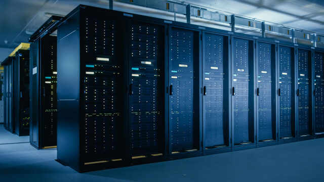 A data center control room filled with rows of servers