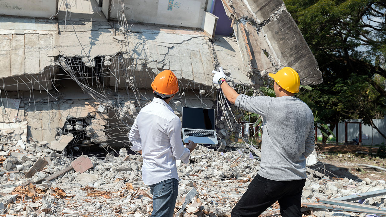 Demolition control supervisor and contractor discussing on collapsed building