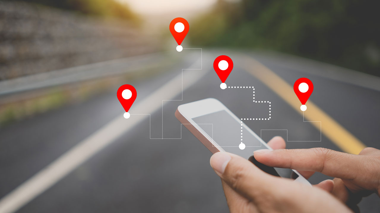 Person holding smartphone with navigator location point on the street background