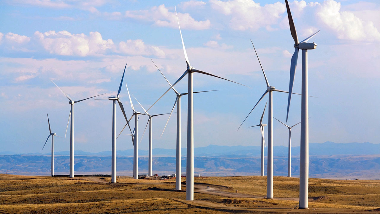 Wind turbines generating clean power in the plains with a blue sky backdrop