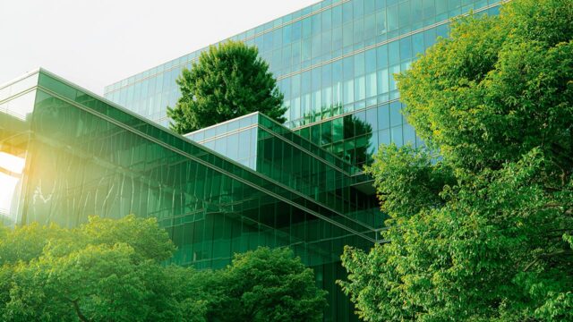 Sustainable glass office building with trees for reducing carbon dioxide