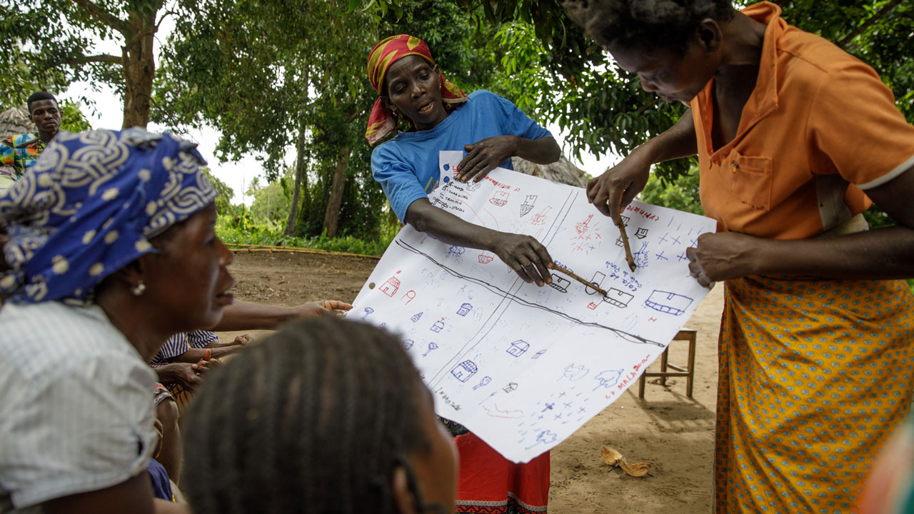 Women in Mozambique show map marcations to a group of villagers