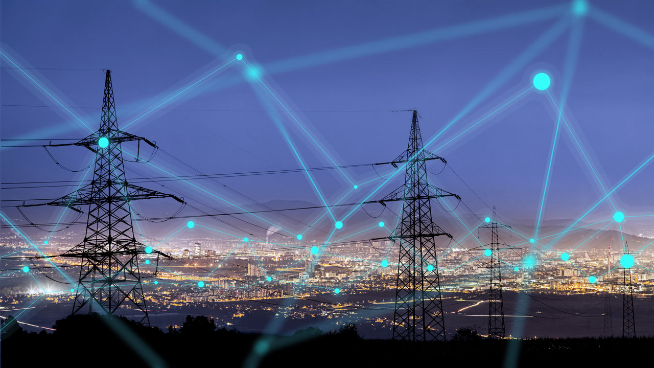 Power lines leading into a large city at night