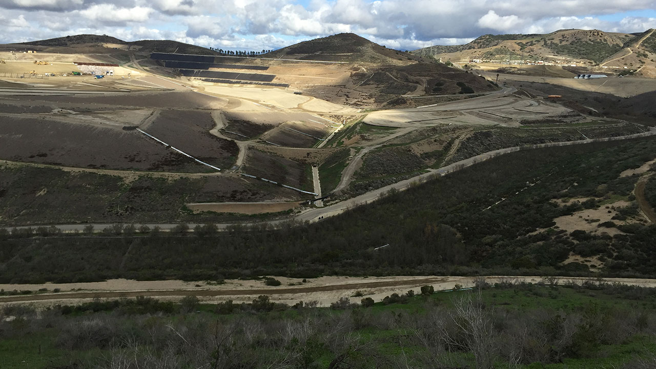 Aerial view of a landfill with clouds in the background