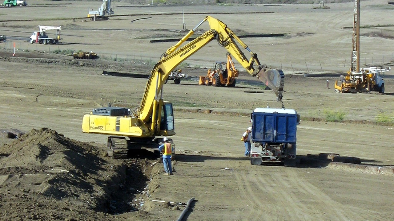 Backhoe throwing dirt on a truck