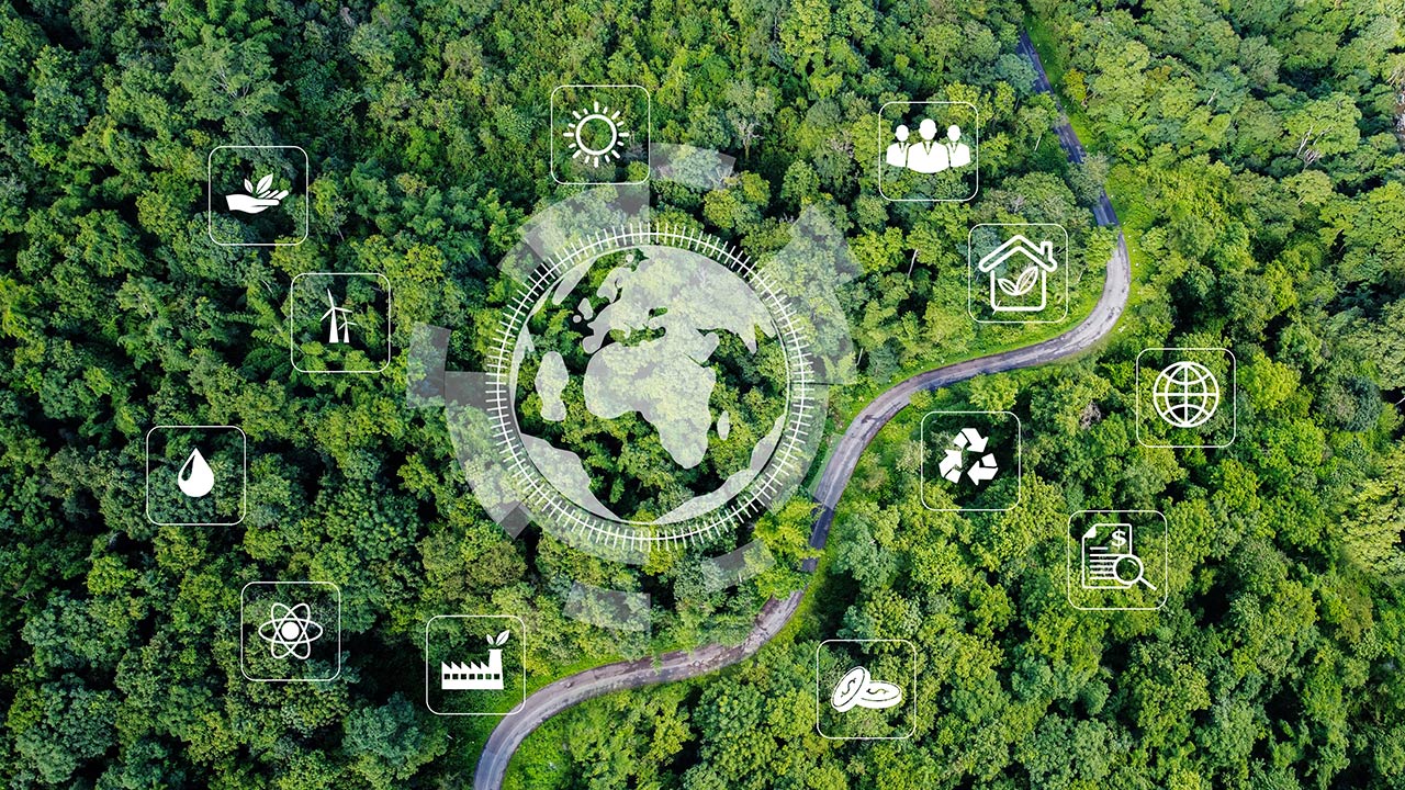 Aerial view of green forest overlayed with a large icon of earth surrounded by smaller environment icons