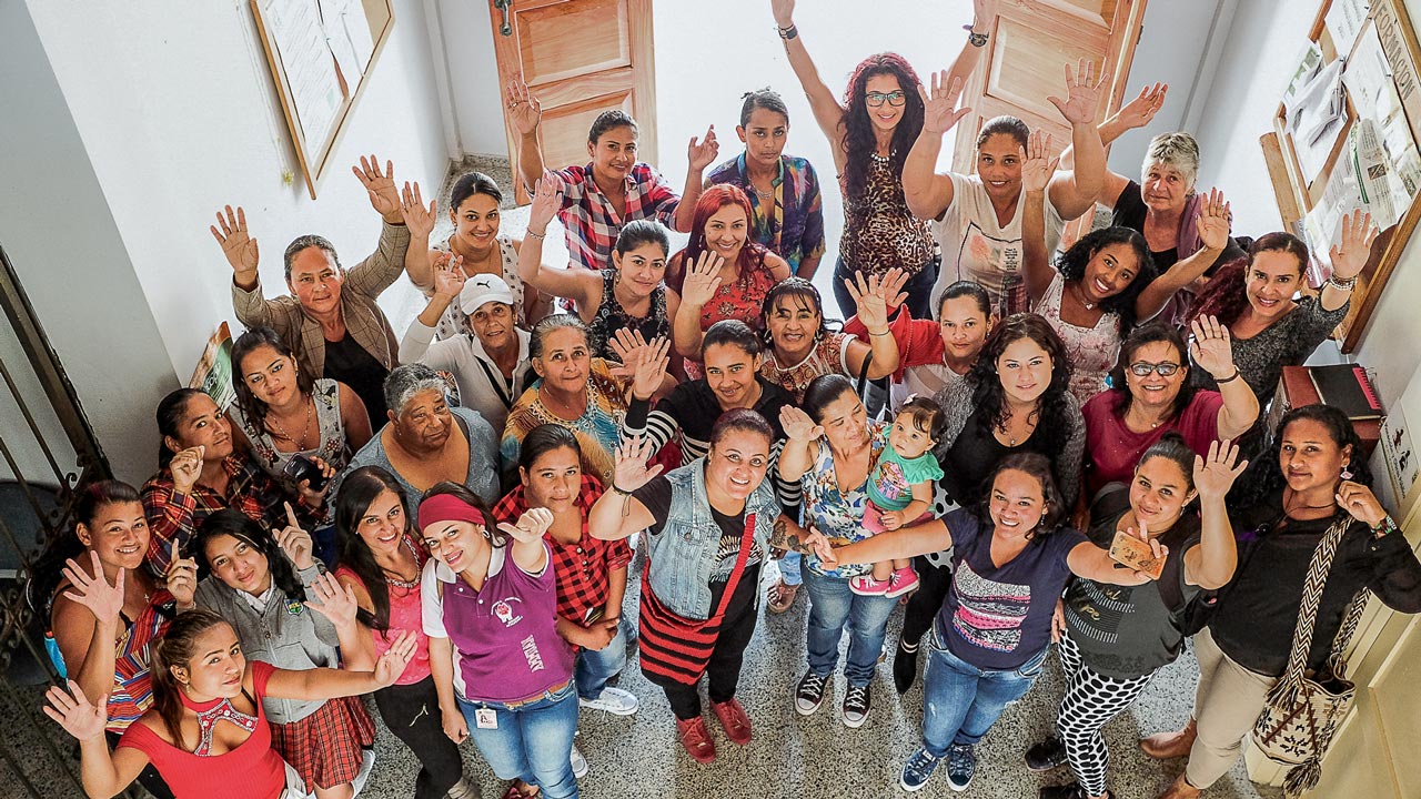 Aerial view of Colombian women and girls with their arms up