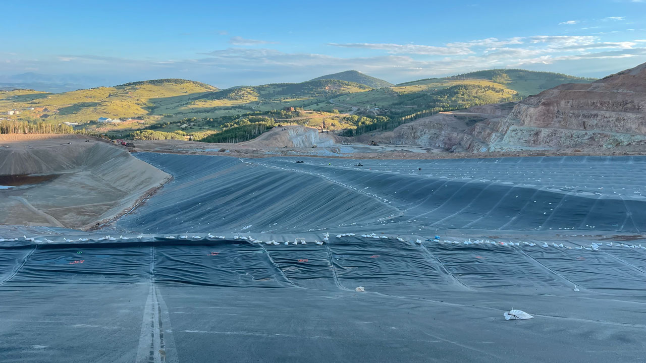 Geosynthetic liner system installation for a leach field expansion at a gold mine, including 70 acres of textured HDPE liner