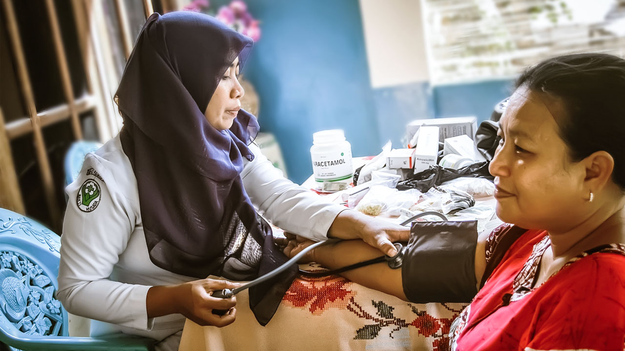 Doctor takes the blood pressure of a woman in the Philippines