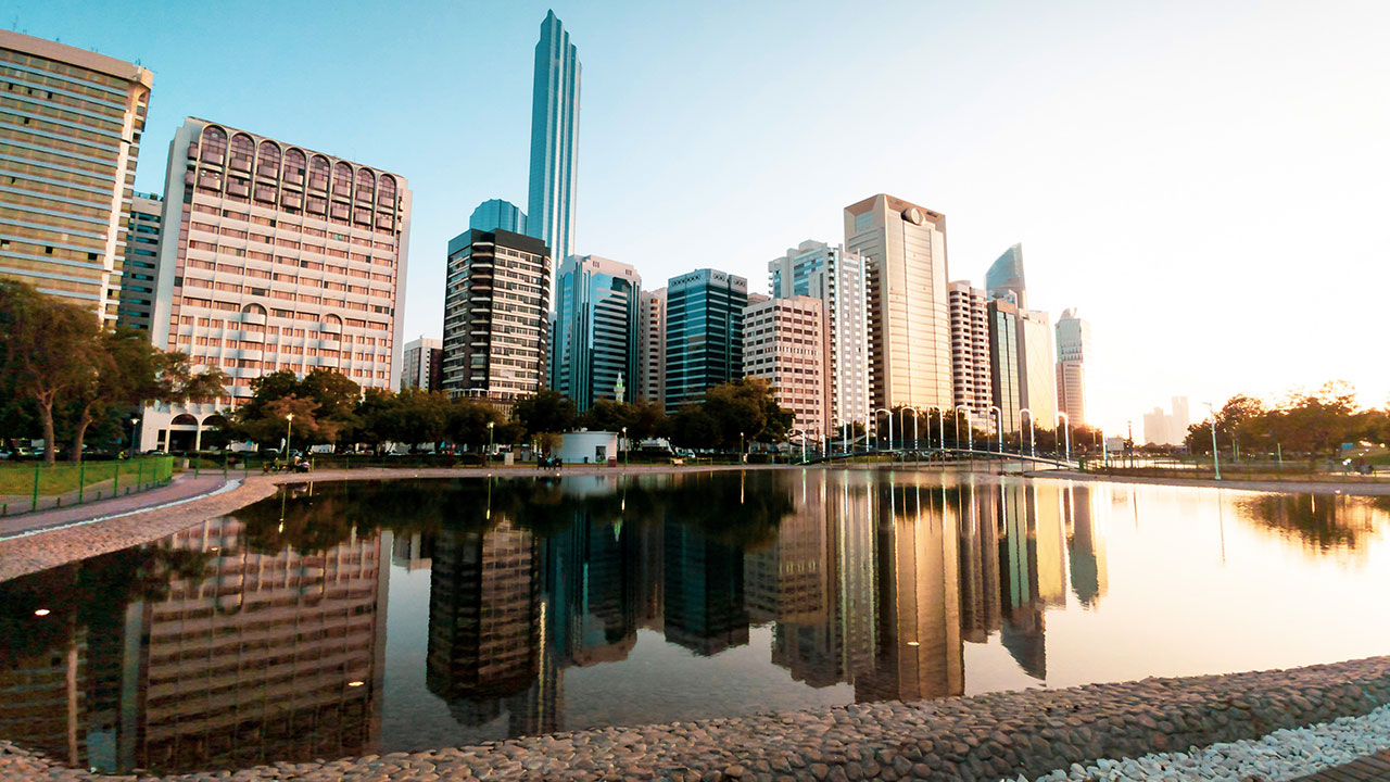 Abu Dhabi downtown cityscape reflected in the water at the Lake park