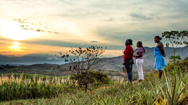 Three women look out on a landscape in Colombia