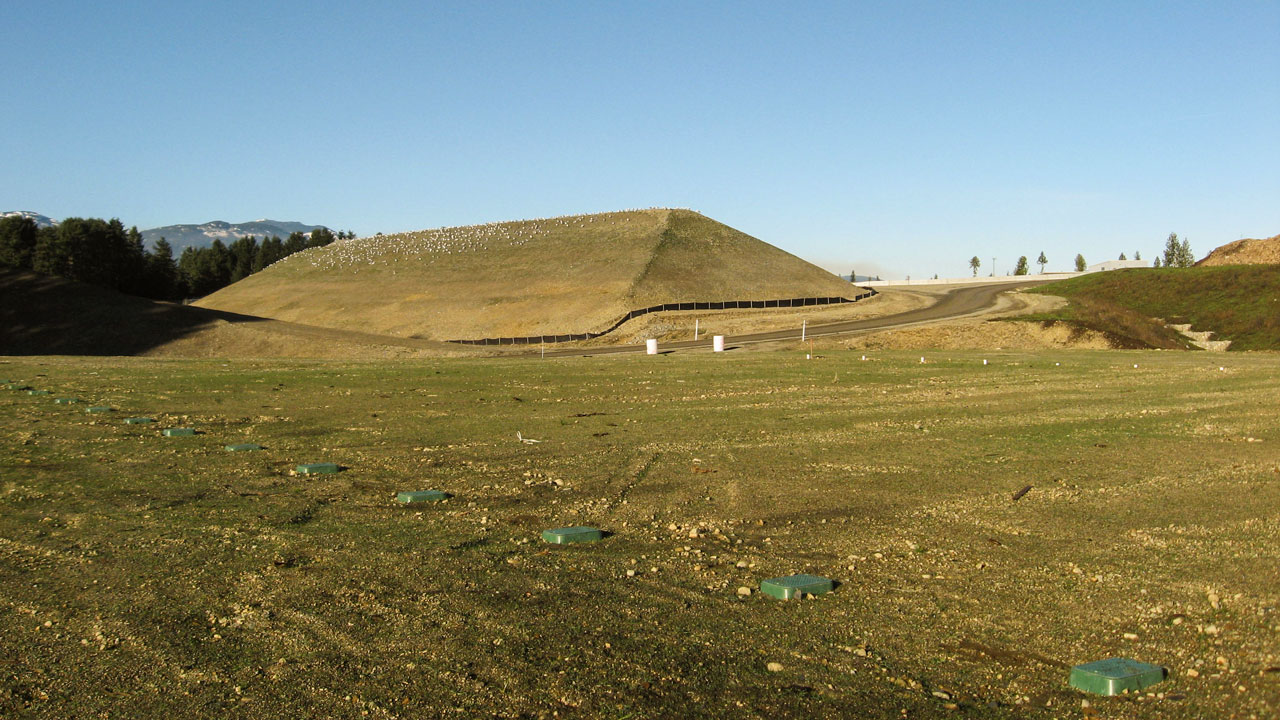 Landfill cover cap for containment of waste materials with a blue sky in the background