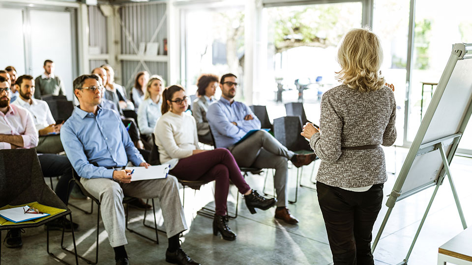 An instructor with a white board presenting to a room of people