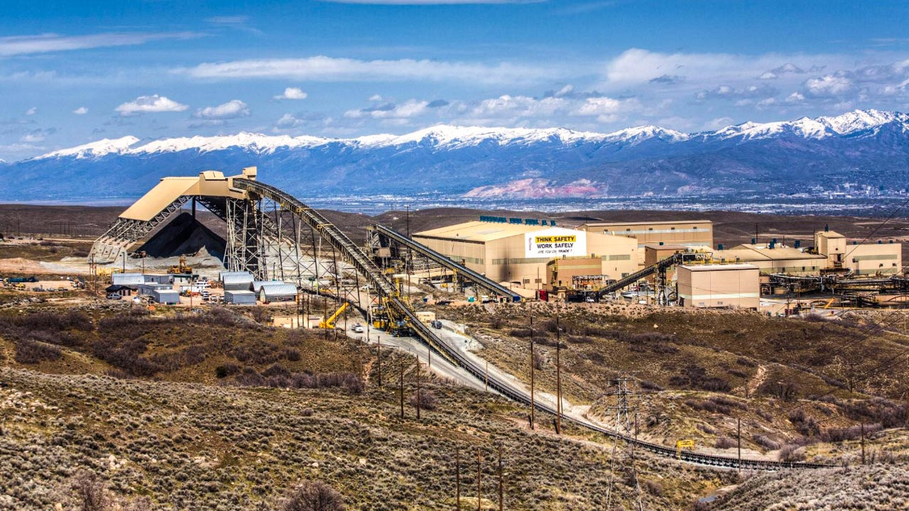 An aerial view of a concentrator plant with mountains and a blue sky in the background