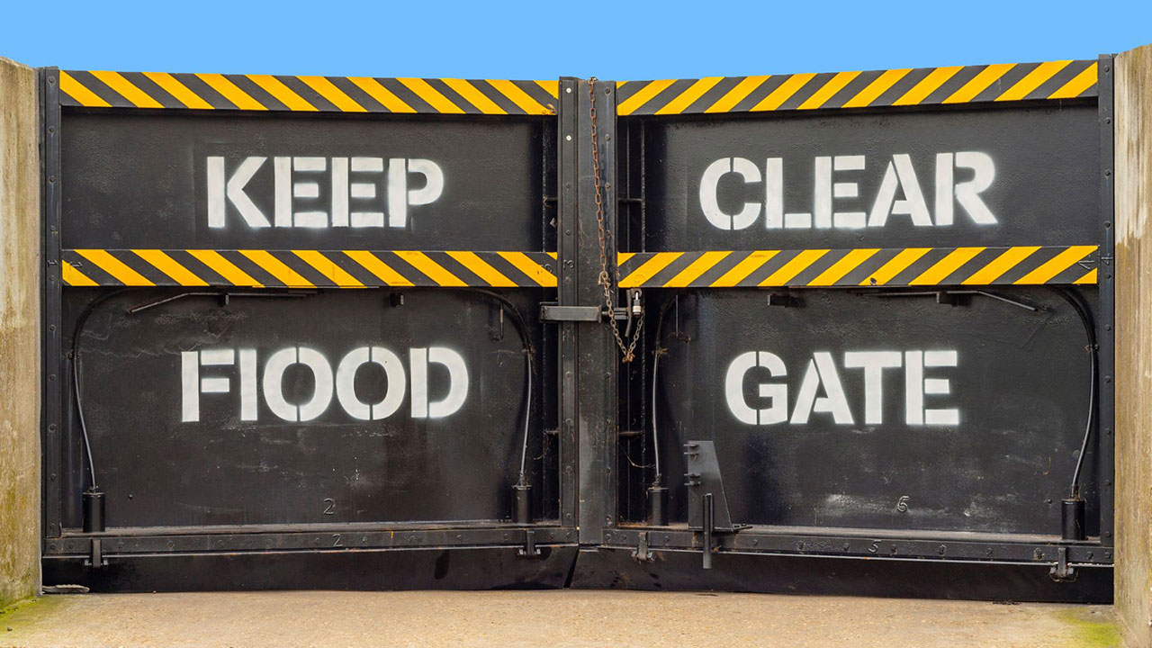 Closed flood gates with “Keep Clear – Flood Gate” painted in white