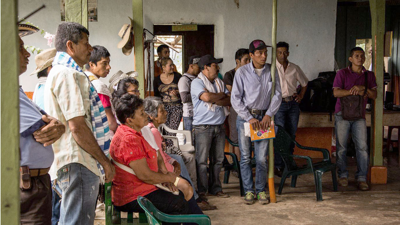 Group of community members stand in a meeting space in Colombia