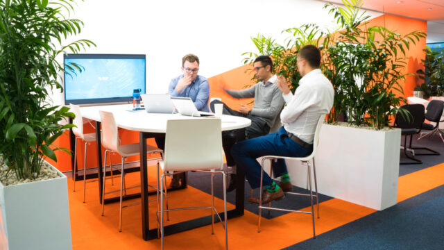 Three engineers sitting at a table having a discussion