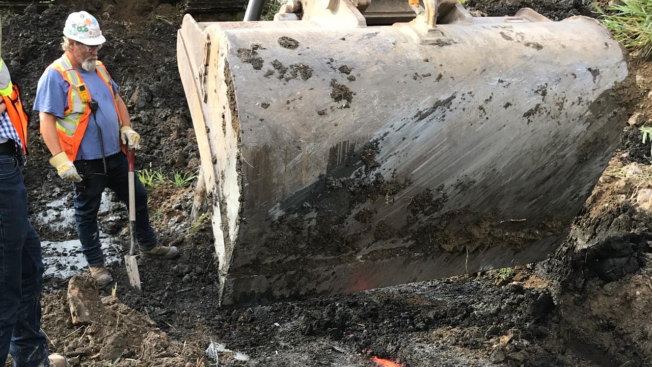 Two workers overseeing a removal of gas conveyance piping