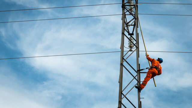 A lineworker tests for faults on medium-voltage power lines in Abuja, Nigeria