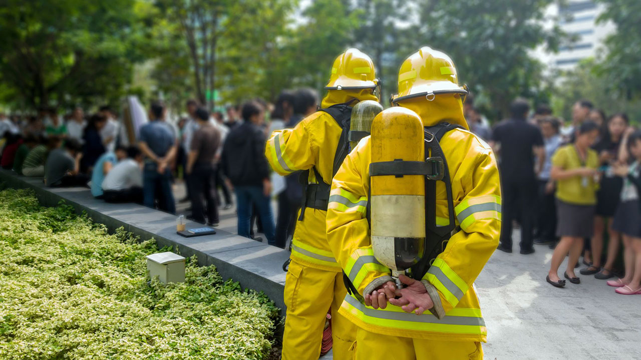 Firefighters and office workers practice emergency evacuation of high rise