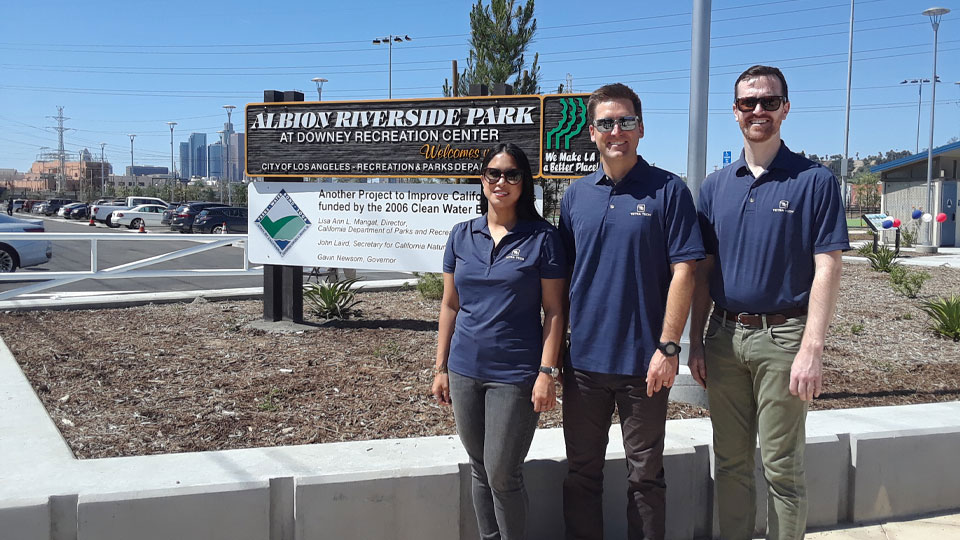 Tetra Tech project team members take a group photo in front of the Albion Riverside Park sign