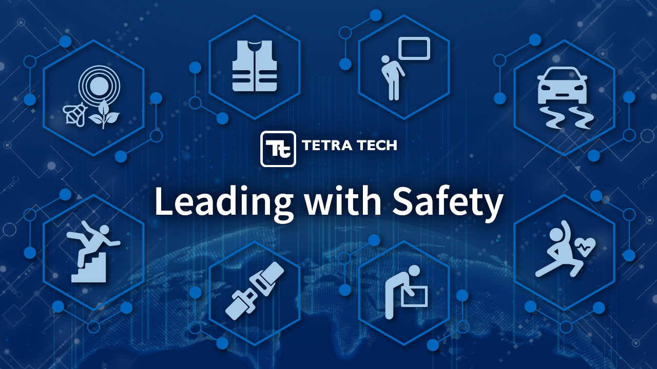 Blue graphic with health and safety icons and the words “Leading with Safety”
