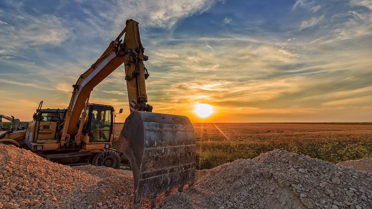 Excavator in construction site at stunning sunset