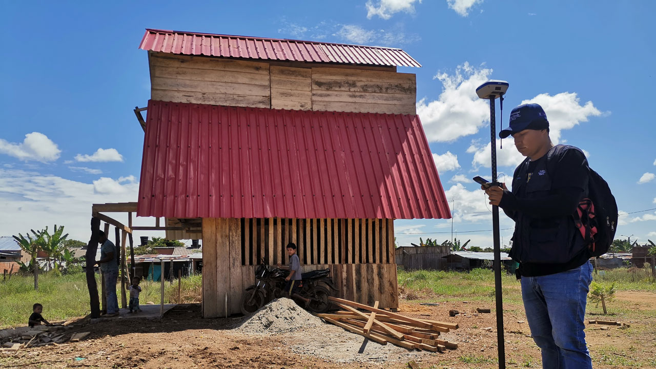 A man in Colombia measures the stability of the land below residential infrastructure