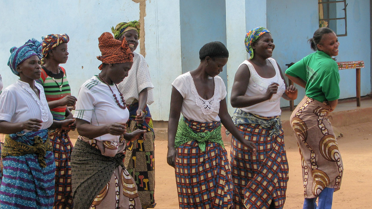 Members of community dance troop and Chipata District Land facilitator, Misozi Banda celebrate land certificates