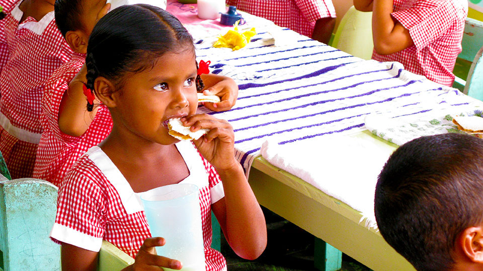 Girl eating, part of BIFAD’s global support for food security and fighting hunger
