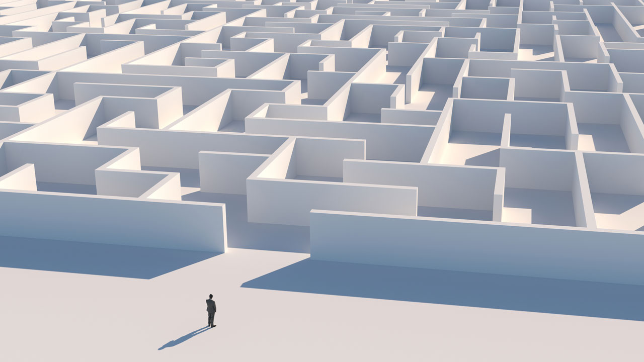 A man stands in front of a maze, representing different paths to take for decision-making
