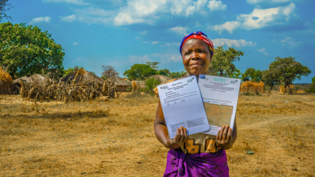 A Zambian woman holds her legal property documents as a result of TGCC project interventions
