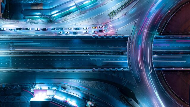 Aerial view of an expressway at night with car traffic above intersection